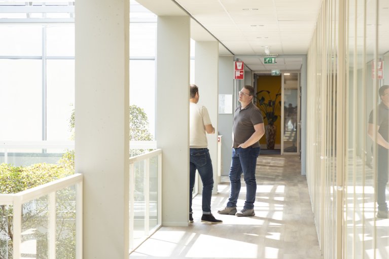 Collega's staan te overleggen op de gang