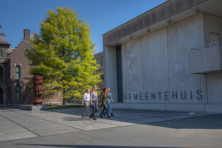 4 collega's  lopen voor het gemeentehuis