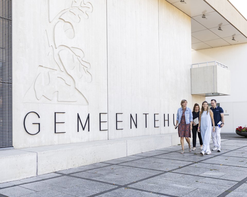 Medewerkers wandelen langs het gemeentehuis